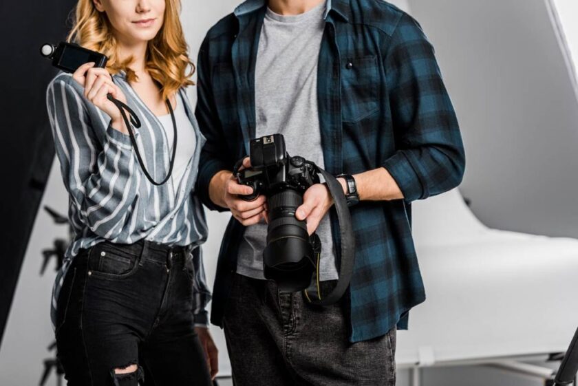 man and woman holding camera gear in studio