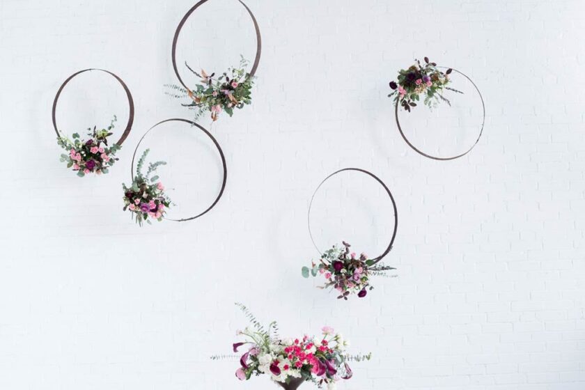 metal hoops with floral arrangements on white wall