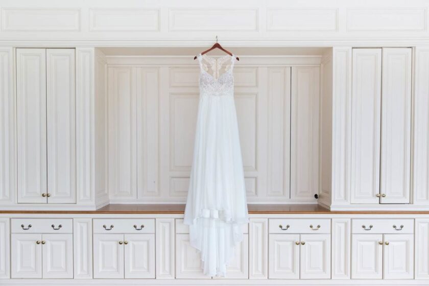 wedding dress hanging on white cabinet wall